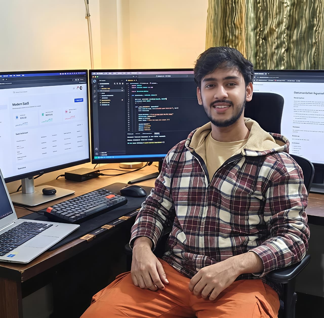Sahal Shaikh at his three-monitor workspace, mid-build.